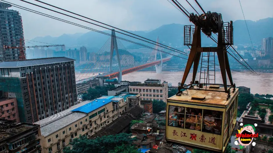 重庆长江索道运行中，载满游客的缆车跨越江面，远处能看到大桥与山城建筑